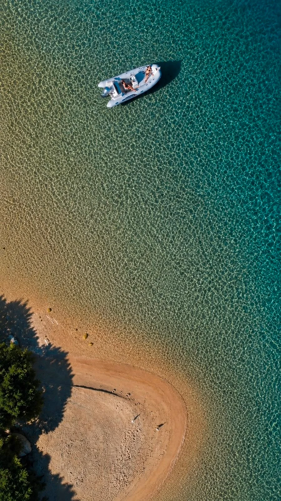 Gommone presso una spiaggia di sabbia chiara nell'arcipelago di La Maddalena
